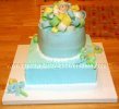 blue baby boy cake with fondant ribbon and little baby on top