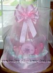 diaper cake with pink satin ribbon around layers and tied with white tulle