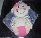 cute baby girl cake made out of 2 round cakes with pink headband