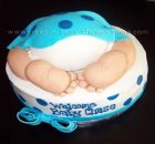 white and blue cake with a baby bum and feet sticking out covered with blue blanket