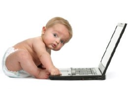 baby typing on computer and looking at camera