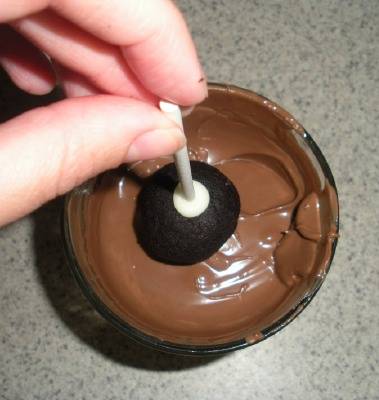 dipping cake pop into chocolate