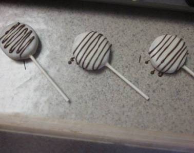 white chocolate chocolate covered oreo lollipops drizzeled with chocolate