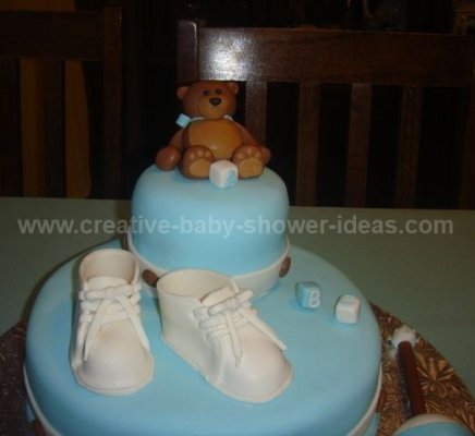 closeup of brown bear on top of baby bootie cake