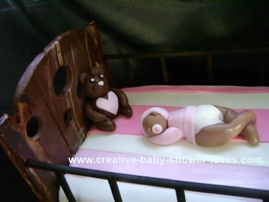 close up of baby sleeping in baby shower crib cake