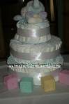 soft white elephant diaper cake with satin ribbon and pastel baby blocks