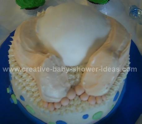 blue and green polka dot cake with baby crashing into it