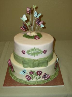 white cake with green bow and purple flowers