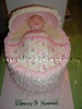pink and white baby bassinet cake with white ruffles and edible bassinet hood