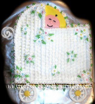 white basket weave baby carriage cake with smiling baby peeking out