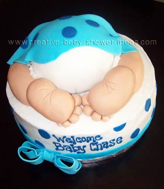 baby rump cake with blue polka dot blanket on top and toes sticking out