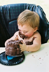 messy baby eating chocolate cake