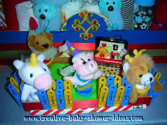 closeup of animal ride car infront of diaper cake made with supplies and stuffed animals