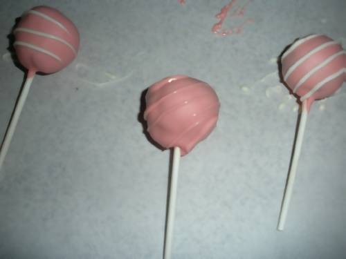 pink cake pops drizzled with pink and white candy melts