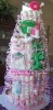 tall pink and green diaper cake with m&m baby clothing and toys
