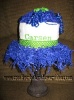 1 tier diaper cupcake wrapped in a white burp cloth and decorated with green polka dot ribbon and blue shred paper