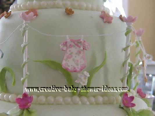 closeup of baby clothes on fairy garden shower cake