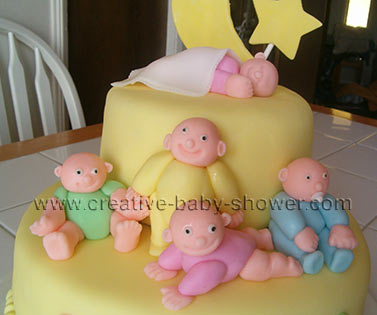 2 tier yellow fondant cake with sleeping babies and moon and stars