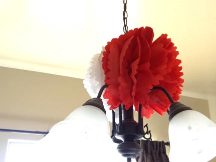 large white and red paper flowers hanging on light