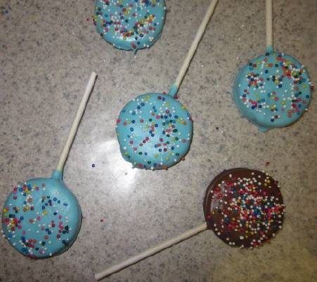 blue and chocolate brown oreo cookie pops with colored sprinkles