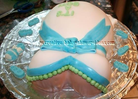 top view of  pregnant belly cake showing green necklace