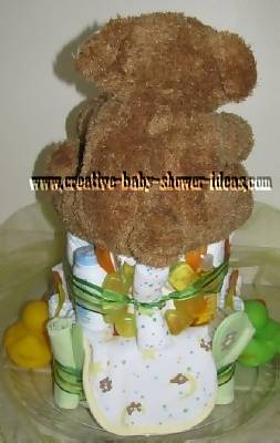 back of green and yellow teddy bear diaper cake