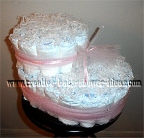 white baby bootie diaper cake tied with pink tulle 