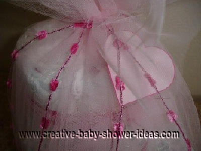 diaper cake tied with white tulle and a pink heart card