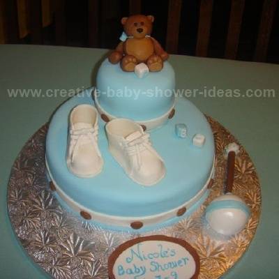 blue baby cake with chocolate dots white booties and brown bear