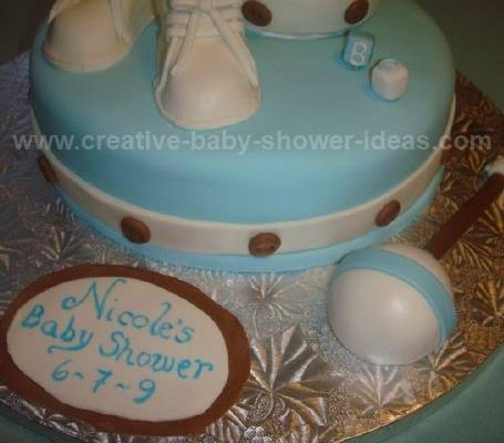 closeup of blue and white baby bootie cake with rattle
