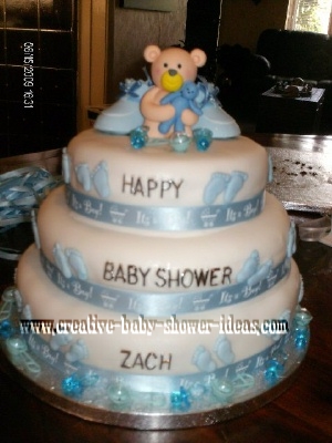 white fondant baby bootie cake with blue footprints