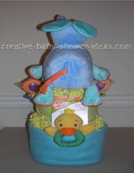 back of elephant diaper cake with blue and green blankets surrounding layers and yellow ducky toy sticking out