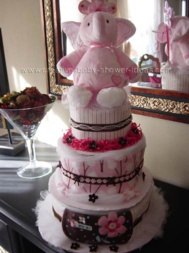 pink and brown elephant diaper cake with modern pink and brown baby blankets covering the layers