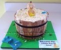 smiling baby in a barrell bathtub cake with white bubbles and baby toys