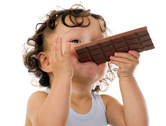baby with curly hair eating candy bar