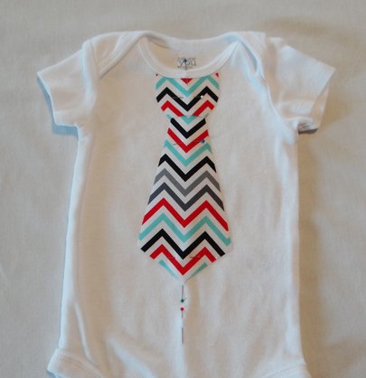 tie pinned in place on baby onesie