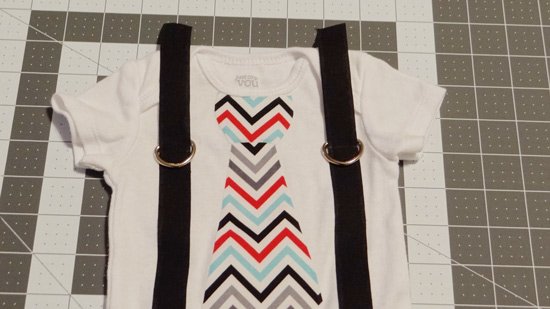 baby onesie showing placement of D rings on suspenders