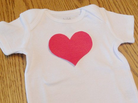 onesie on ironing board with cut out heart