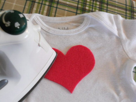 applique heart being ironed onto onesie