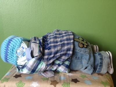 diaper baby in plaid shirt and jeans sleeping on stomach