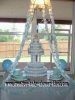 baby shower table with six tier blue diaper cake on a cake stand and 2 edible baby bootie cakes