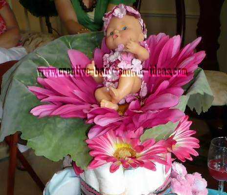 closeup of baby doll on flower diaper cake