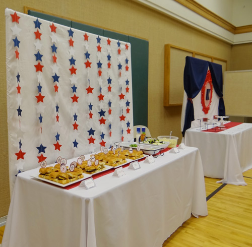 party table with white backdrop and red white and blue garland stars