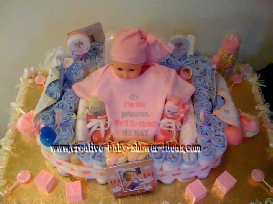 top of baby doll diaper cake showing baby supplies