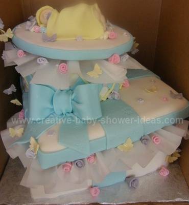 blue and white angled baby shower gift box cake with sleeping baby on top