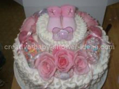 white baby shower cake with pink baby booties and roses