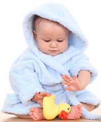 baby in blue hooded bathrobe playing with rubber ducky