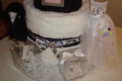 2nd layer of towel cake with tux and wedding dress decorations