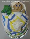 baby sleeping cake with white green and blue blanket and green bear