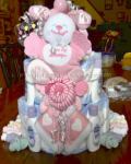 pink and white baby diaper cake with sneakers